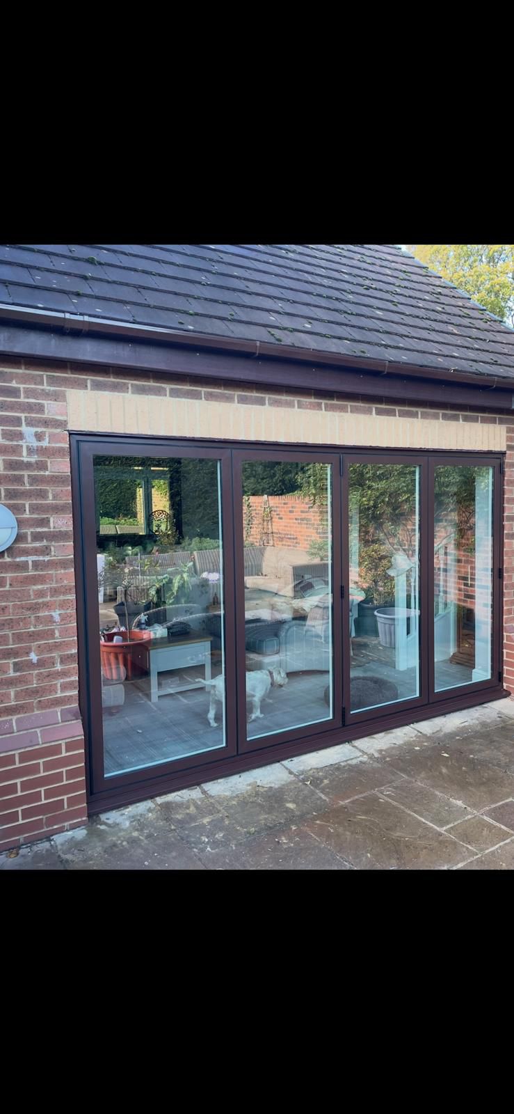 Brown aluminium bifold doors installed by SCH Windows on a North West home