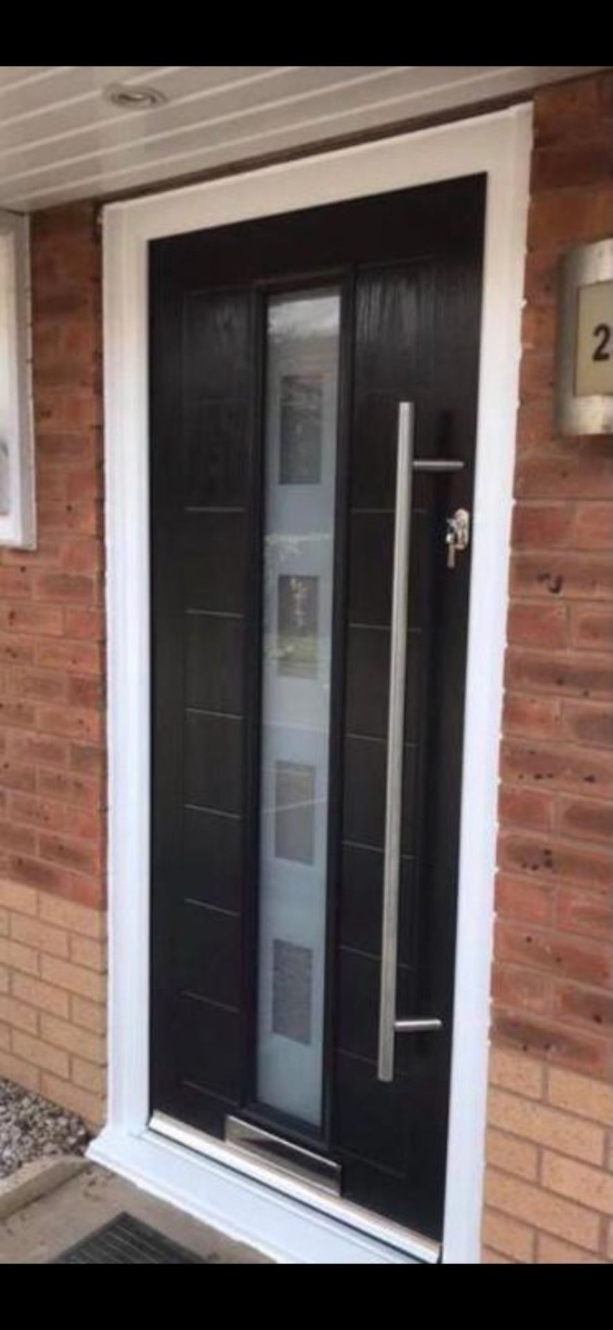 Modern black composite door with vertical frosted glazing